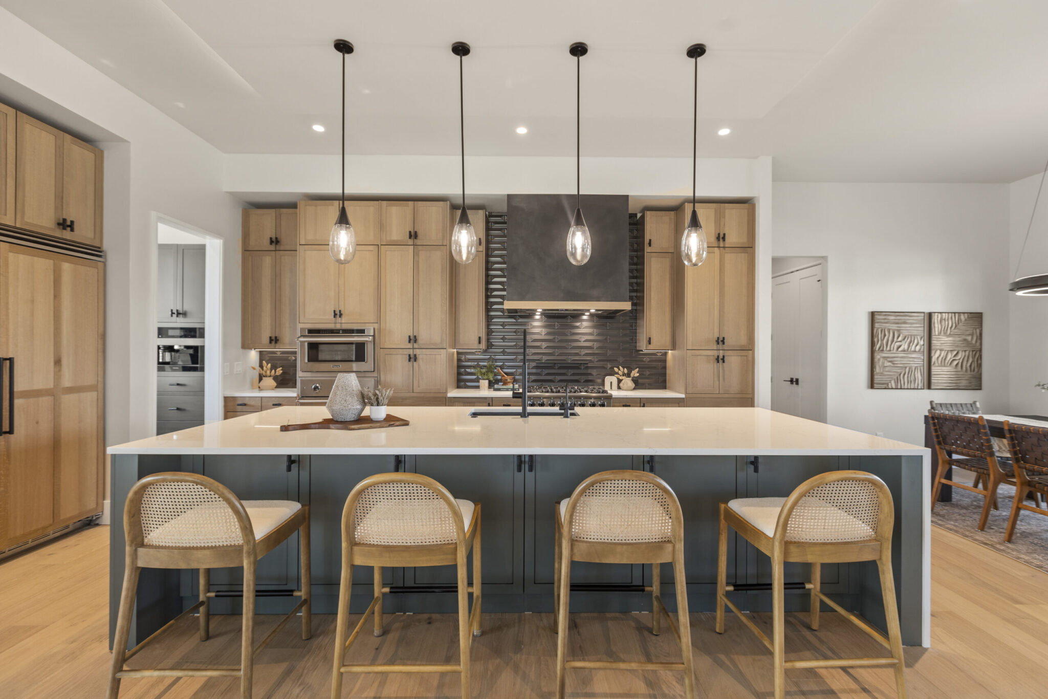 Warm oak and charcoal custom kitchen with a large island and pendant lights